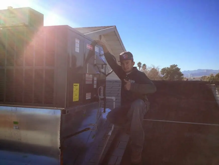 HVAC technician performing AC Tune-Up on a rooftop unit in Calumet City